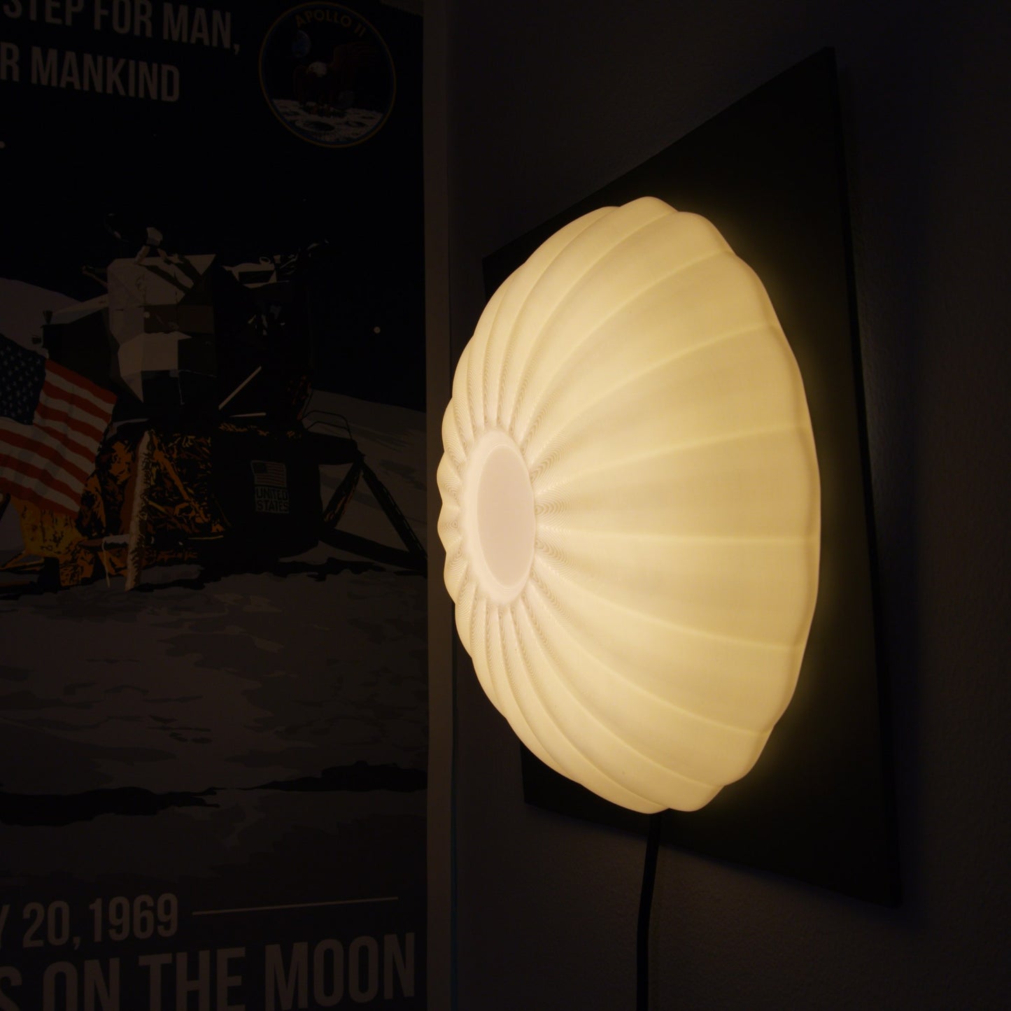Wall-mounted illuminated Kueh Tutu lamp glowing alongside a decorative poster, highlighting its use as ambient wall decor