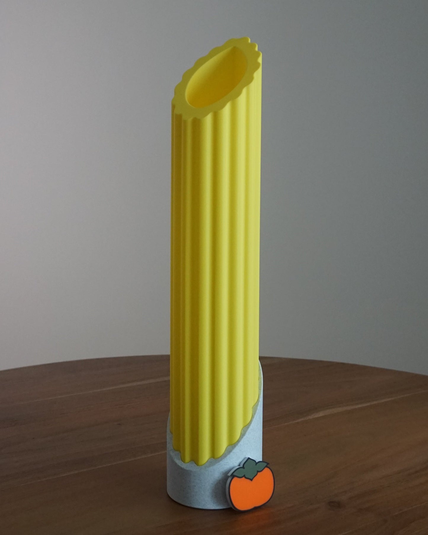 Single Penne pasta lamp featuring a cream white base, unlit in bright daylight and a mini persimmon logo